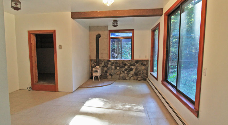Wood stove set in natural creek stone wall.