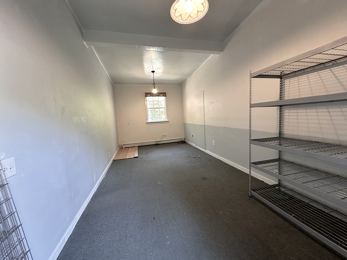 Bay 2 interior—carpeted, white walls, window, and sliding glass door.